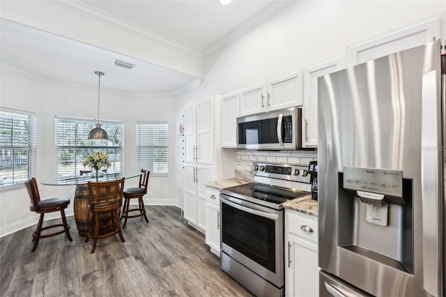 kitchen with visible vents, backsplash, ornamental molding, appliances with stainless steel finishes, and white cabinets