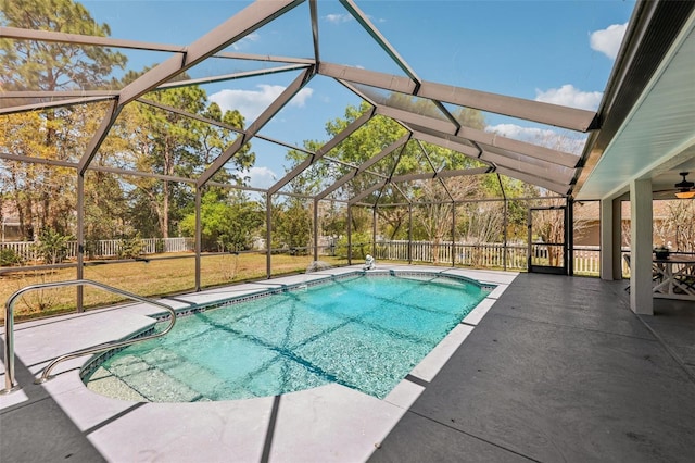 view of swimming pool featuring a lawn, a patio, fence, glass enclosure, and a fenced in pool