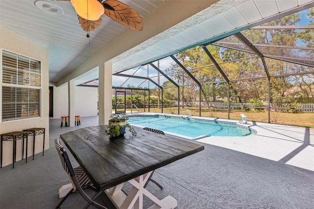 outdoor pool featuring a patio area, glass enclosure, and a ceiling fan