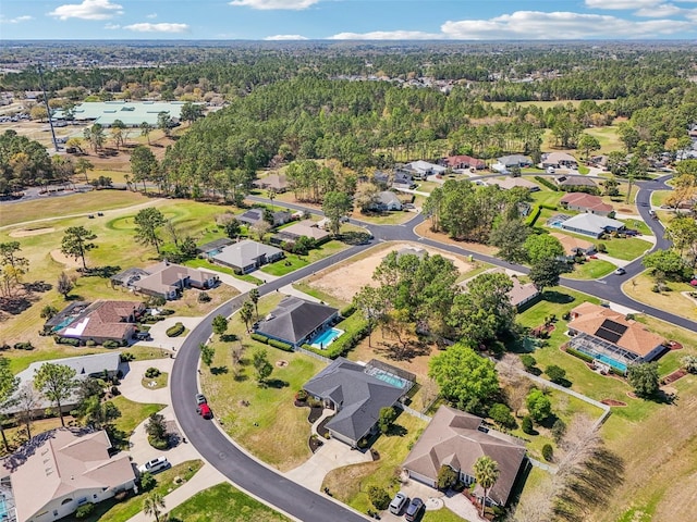 drone / aerial view with a residential view, a view of trees, and a water view