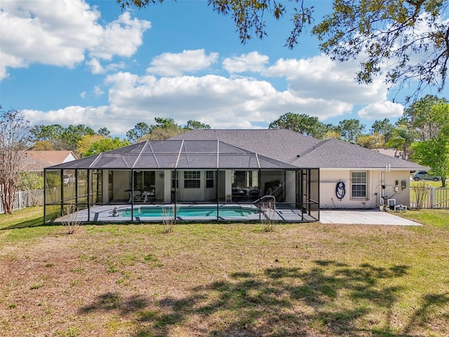 rear view of property with a lawn, a patio, fence, glass enclosure, and a fenced in pool