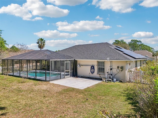 back of property with stucco siding, a patio, a yard, a shingled roof, and a fenced in pool