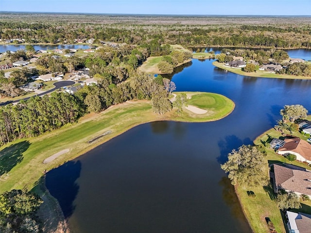 drone / aerial view featuring a wooded view and a water view