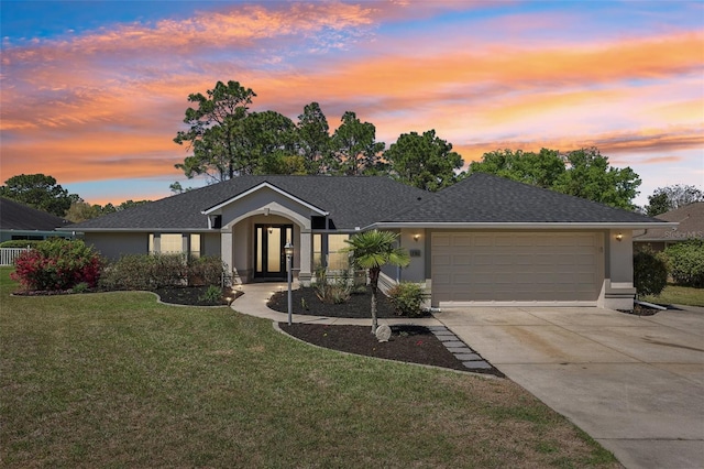 single story home featuring concrete driveway, a yard, a garage, and stucco siding