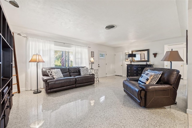 living room with speckled floor, baseboards, a textured ceiling, and visible vents