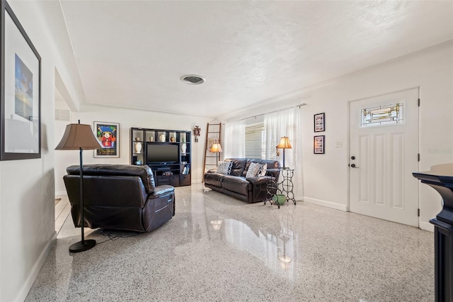 living area with visible vents, speckled floor, and baseboards