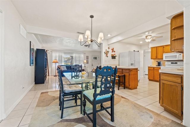 dining area featuring ceiling fan with notable chandelier, light tile patterned floors, visible vents, and baseboards