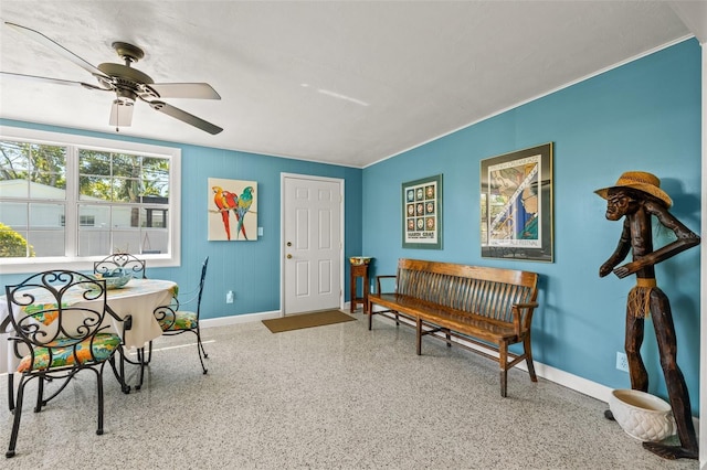 sitting room featuring speckled floor, baseboards, and a ceiling fan