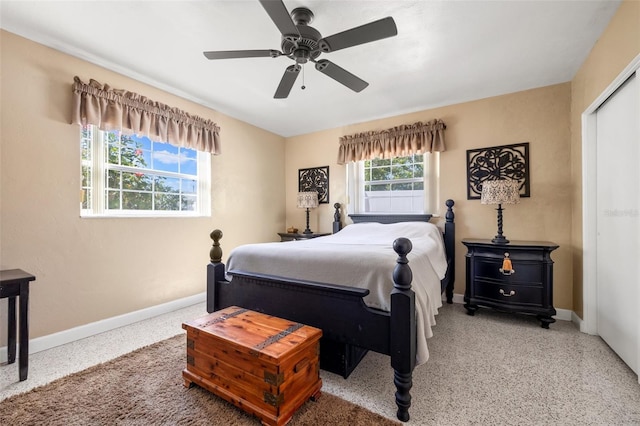 bedroom with speckled floor, a ceiling fan, and baseboards