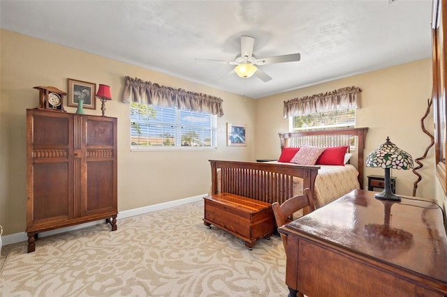 bedroom with light colored carpet, baseboards, and ceiling fan