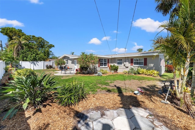 view of front facade with a patio, a front yard, and fence