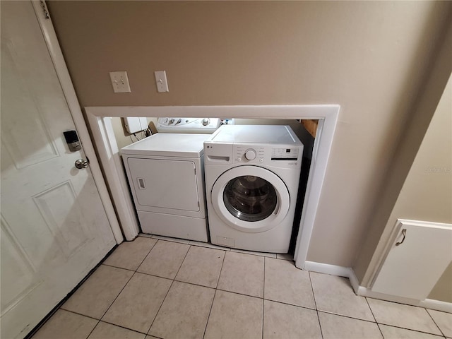 laundry room featuring washer and clothes dryer, laundry area, and light tile patterned floors