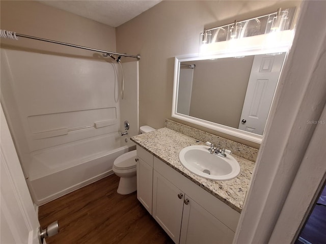 bathroom featuring shower / washtub combination, toilet, vanity, and wood finished floors