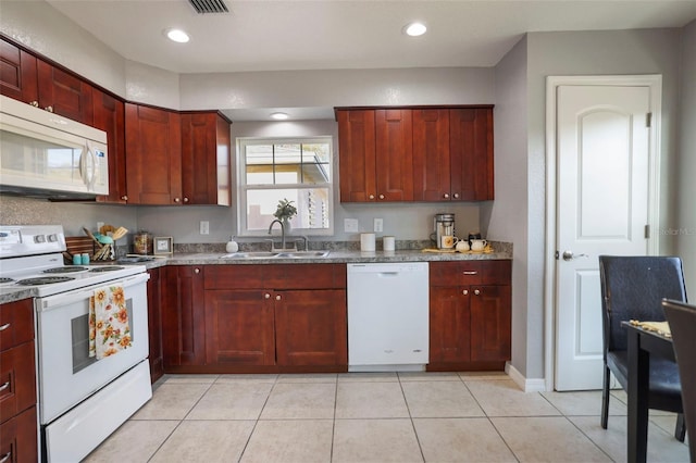 kitchen featuring white appliances, light tile patterned flooring, recessed lighting, a sink, and reddish brown cabinets