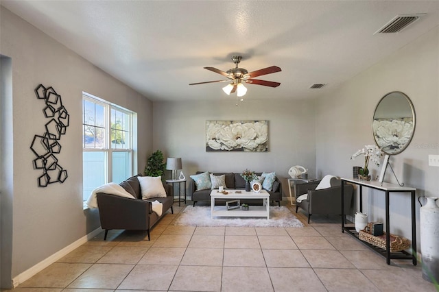 living area with light tile patterned floors, visible vents, baseboards, and a ceiling fan