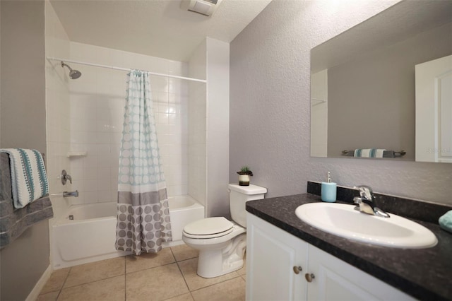 bathroom with vanity, shower / bath combination with curtain, tile patterned floors, toilet, and a textured wall