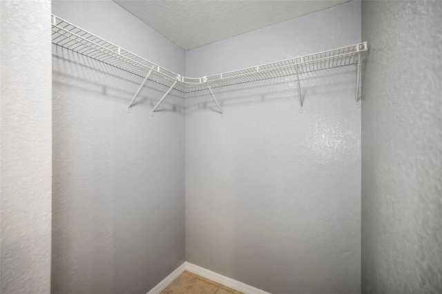 walk in closet with light tile patterned floors