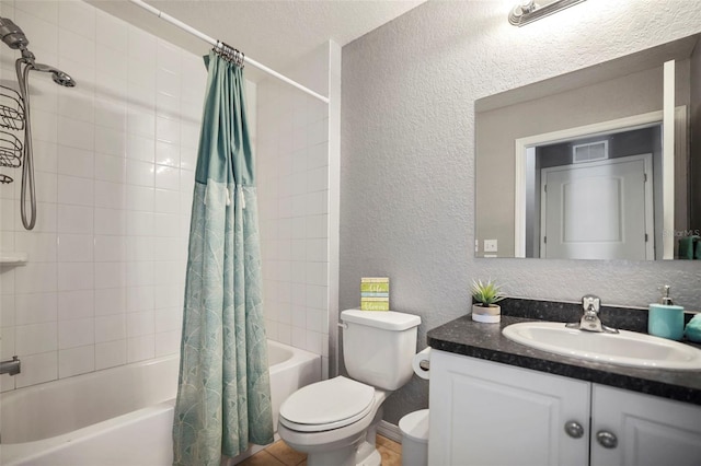 bathroom with vanity, toilet, a textured wall, and shower / bath combo