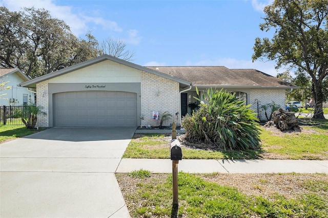 ranch-style home with driveway, brick siding, an attached garage, and fence