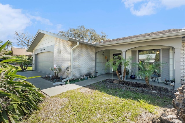 single story home with a garage, brick siding, and a porch