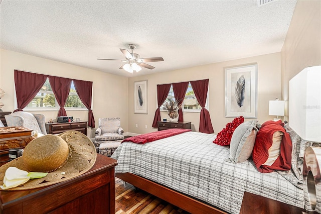 bedroom featuring a textured ceiling, wood finished floors, and a ceiling fan