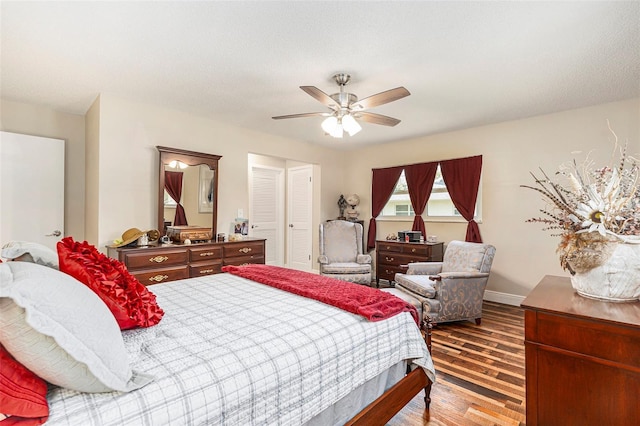 bedroom with ceiling fan, a closet, baseboards, and wood finished floors