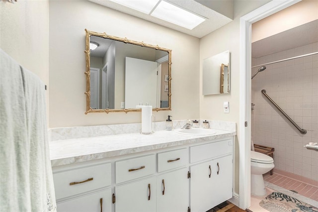 full bathroom with tile patterned floors, tiled shower, toilet, and vanity