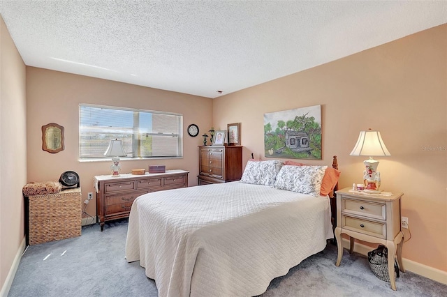 bedroom with a textured ceiling, baseboards, and light carpet