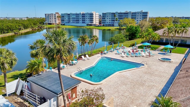 pool with a water view, fence, and a patio area