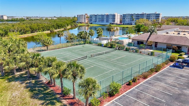 view of sport court with a water view and fence