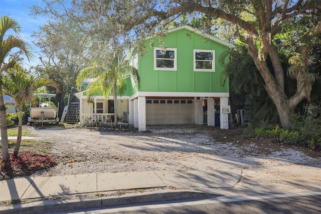 view of front of home featuring stairway, a garage, and driveway