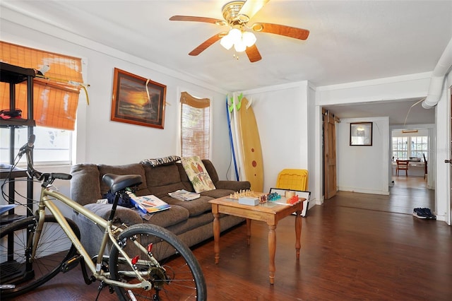 living room with baseboards, a ceiling fan, and wood finished floors