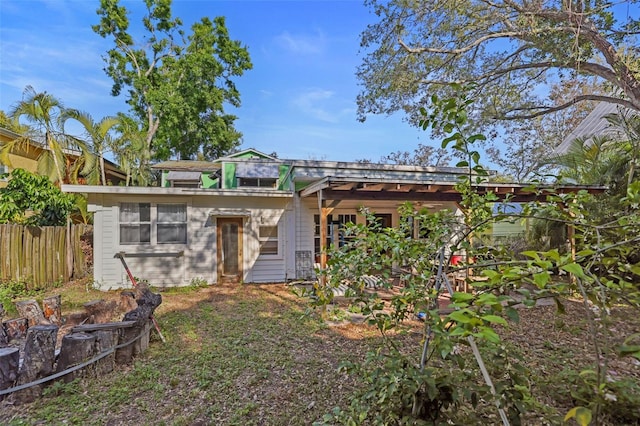 rear view of house featuring fence