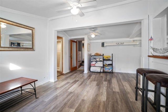 dining space with baseboards, crown molding, a ceiling fan, and wood finished floors