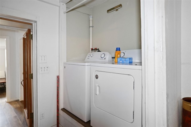 clothes washing area with laundry area, independent washer and dryer, and wood finished floors