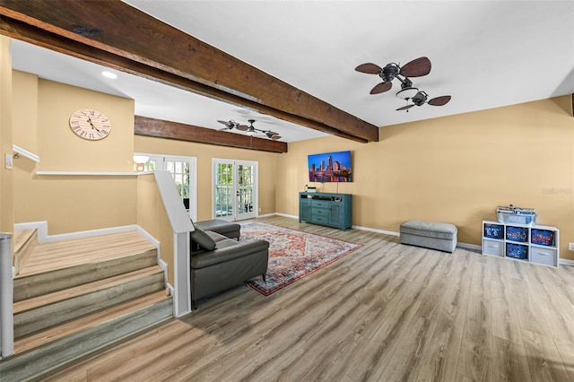 living room with beamed ceiling, wood finished floors, french doors, baseboards, and stairs