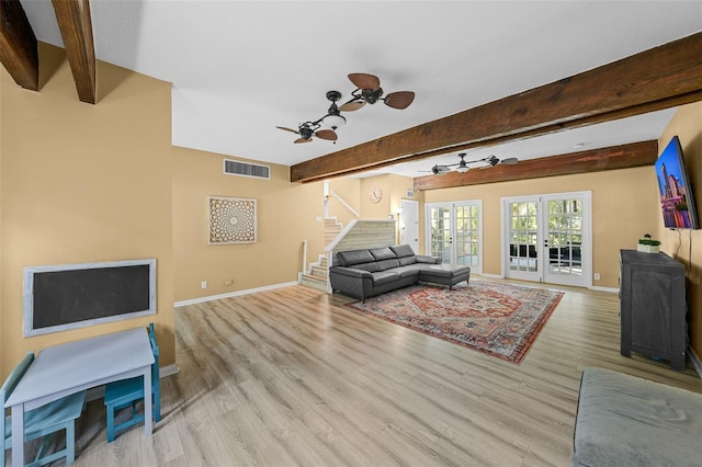 living area with stairway, wood finished floors, visible vents, beam ceiling, and french doors