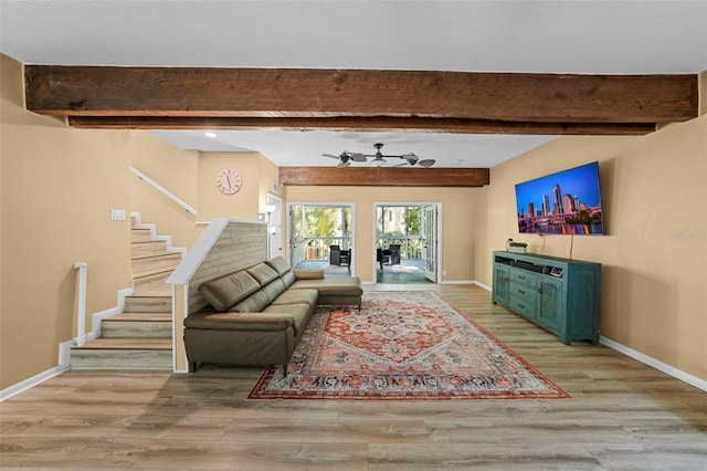 living room with beam ceiling, stairway, wood finished floors, and baseboards