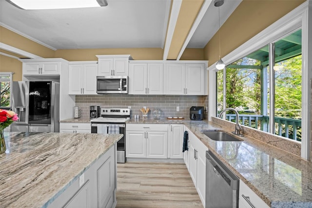 kitchen featuring a sink, backsplash, appliances with stainless steel finishes, and light wood-style flooring