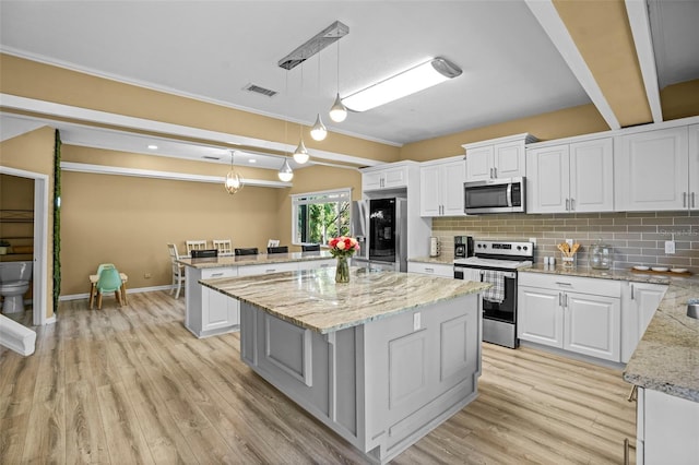 kitchen featuring visible vents, decorative backsplash, appliances with stainless steel finishes, light wood-style floors, and white cabinetry