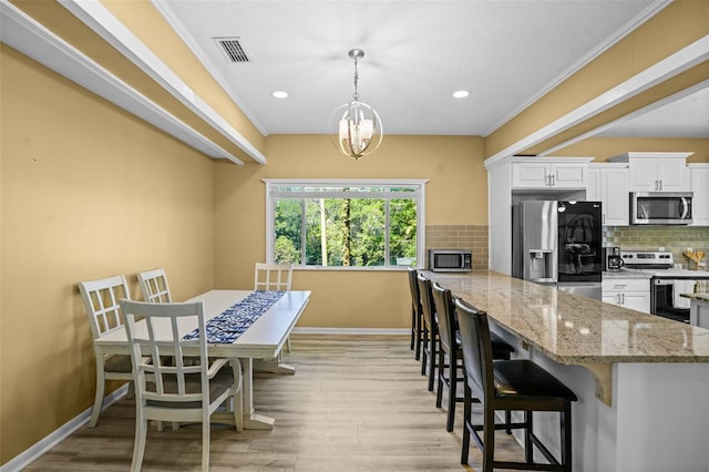 kitchen with visible vents, light wood-style flooring, white cabinets, appliances with stainless steel finishes, and tasteful backsplash