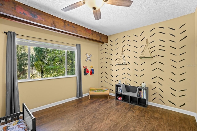 unfurnished bedroom featuring a textured ceiling, a ceiling fan, baseboards, and wood finished floors