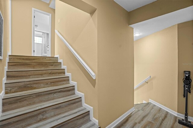 stairway featuring baseboards and wood finished floors