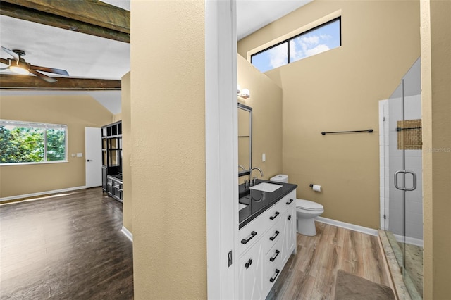 bathroom featuring a wealth of natural light, a shower stall, toilet, and wood finished floors