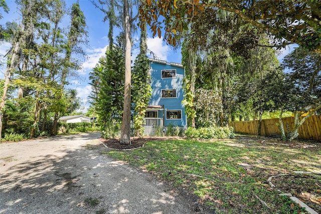 view of front of house with driveway and fence