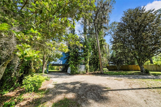 view of yard featuring driveway and fence