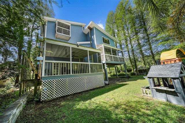 rear view of house featuring a yard and a sunroom