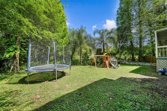 view of yard featuring a playground, a trampoline, and fence