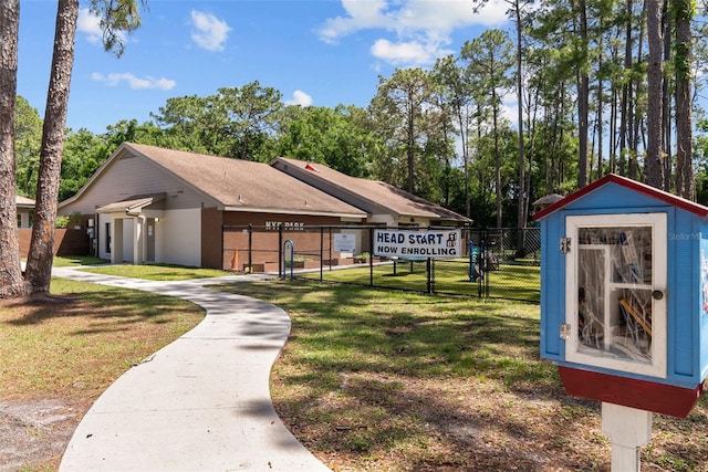 view of community featuring a gate, an outbuilding, a yard, and fence