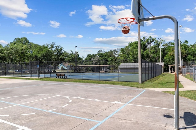 view of basketball court featuring community basketball court, fence, and a tennis court